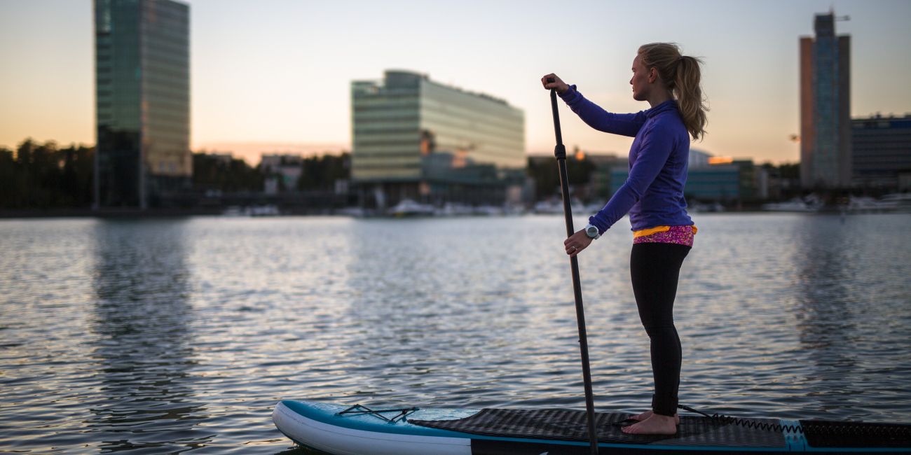 girl on sup board, city view